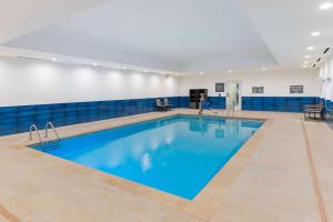 a large swimming pool in a gym with blue tiles at La Quinta Inn & Suites by Wyndham Texas City I 45 in Texas City +29 photos