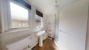 baño blanco con lavabo y ventana en 15 Trevithick Court, Tolroy Manor, en Hayle 14 fotos más