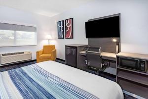 a hotel room with a bed and a flat screen tv at AmericInn by Wyndham Quincy in Quincy