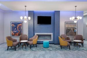 a waiting room with chairs and a fireplace at La Quinta Inn & Suites by Wyndham Galveston North at I-45 in Galveston