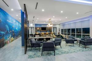 加爾維斯敦的住宿－La Quinta Inn & Suites by Wyndham Galveston North at I-45，一间设有椅子的等候室和一间餐厅