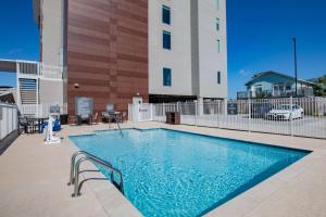 a swimming pool in front of a building at La Quinta Inn & Suites by Wyndham Galveston North at I-45 in Galveston