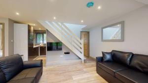 a living room with a couch and a staircase at 48 Trevithick Court, Tolroy Manor in Hayle