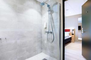 W łazience znajduje się prysznic ze szklanymi drzwiami. w obiekcie Bergen Harbour Hotel, WorldHotels Crafted w Bergen