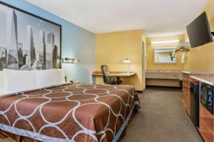 Pokój hotelowy z łóżkiem i biurkiem w obiekcie Super 8 by Wyndham Findlay w mieście Findlay
