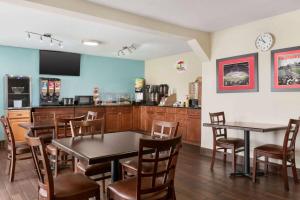 a restaurant with tables and chairs and a kitchen at Super 8 by Wyndham Findlay in Findlay