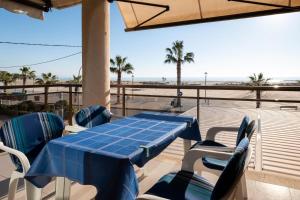 einen Tisch und Stühle auf einem Balkon mit Blick auf den Strand in der Unterkunft AT118 Solarium Mar in Torredembarra
