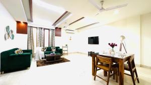 a living room with a table and a green couch at Olive Service Apartments - Green Park in New Delhi