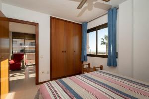 a bedroom with a bed and a window and a chair at AT118 Solarium Mar in Torredembarra