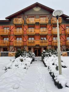 a building with snow in front of it at Comfortable One-Bedroom Apartment TATRAGOLF in Veľká Lomnica