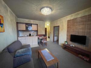 a living room with a couch and a table at Comfortable One-Bedroom Apartment TATRAGOLF in Veľká Lomnica