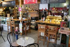 a woman standing in a restaurant with a child in front of a counter at Garden House in Budapest