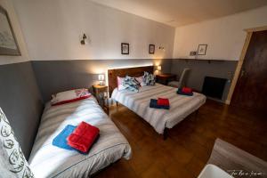 a bedroom with two beds with red and blue pillows at Casa Olmi in Castiglione dʼIntelvi