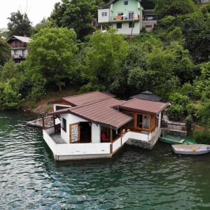 a small house on a boat in the water at Holiday Home Nur in Konjic