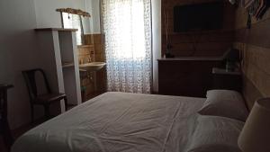 カスティリオーネ・ディンテルヴィにあるCasa Olmiのベッドルーム1室(ベッド1台、シンク、窓付)