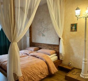 two beds in a bedroom with curtains and a lamp at Gemütliche Apartments AMT in Plauen