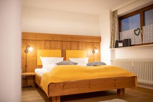 um quarto com uma cama grande e um cobertor amarelo em Loewenzahn em Grainau