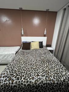 Dormitorio con cama con manta de leopardo en flat reg central sp varanda e Wi-Fi grátis 500 megas, en São Paulo