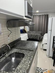cocina con fregadero y cocina con sofá en flat reg central sp varanda e Wi-Fi grátis 500 megas, en São Paulo