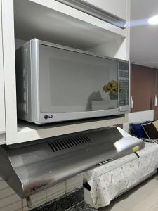 een magnetron op een plank in een keuken bij flat reg central sp varanda e Wi-Fi grátis 500 megas in Sao Paulo