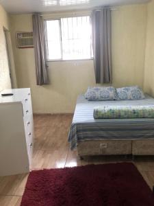 1 dormitorio con 1 cama, vestidor y ventana en Hostel Horizonte de Minas, en Belo Horizonte