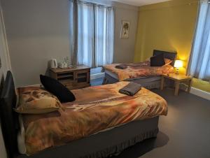 um quarto de hotel com duas camas e uma mesa com mesa de cabeceira em The Fox em Bristol