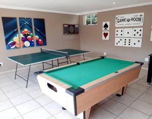 a room with two ping pong tables and a calendar at Umkhomo Place, Mangrove Beach Estate in Port Shepstone