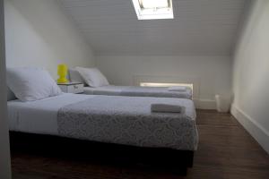 a bedroom with two beds and a skylight at WW Hostel & Suites in Coimbra