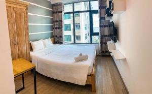 ニャチャンにあるHappy Banana Apartmentのベッドと窓のある小さな寝室 +83枚の写真