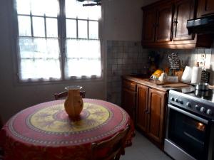 uma cozinha com uma mesa com um vaso sobre ela em La maison des amoureux de ballades dans le Jura 