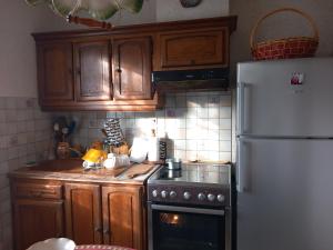 uma cozinha com armários de madeira e um frigorífico branco em La maison des amoureux de ballades dans le Jura 
