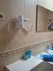 a bathroom with a light on the wall next to a sink at Orlanda Veríssimo in Nazaré