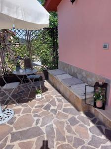 un patio con mesa y sombrilla en B&B Ferro di Cavallo, en Tívoli
