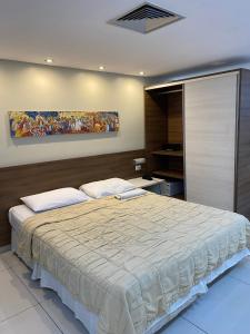 a bedroom with a large bed and a painting on the wall at Imperial Flat Tambaú - João Pessoa - APARTAMENTO 127 in João Pessoa