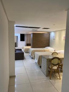 um quarto de hotel com duas camas e uma mesa em Imperial Flat Tambaú - João Pessoa em João Pessoa