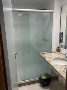 a glass shower in a bathroom with a sink at Imperial Flat Tambaú - João Pessoa in João Pessoa