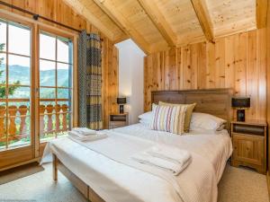 ein Schlafzimmer mit einem Bett und einem großen Fenster in der Unterkunft Chalet Haute Vue in La Tzoumaz