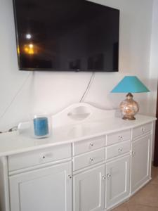 a white bathroom sink with a blue lamp on a dresser at Orlanda Veríssimo in Nazaré