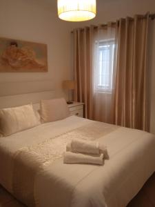 a bedroom with a bed with two towels on it at Orlanda Veríssimo in Nazaré