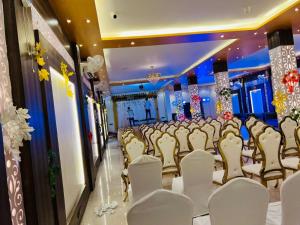 a row of chairs in a banquet hall with lights at The Four Seasons Hotel in Sultānpur