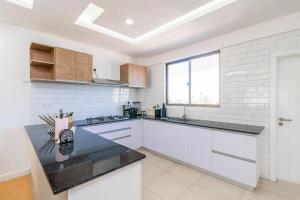 a white kitchen with white appliances and a window at Home Sweet Home in Nairobi
