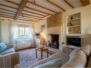 sala de estar con sofá y chimenea en Swift Cottage en Blockley