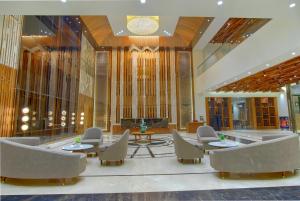 a lobby with chairs and tables in a building at Sayaji Morbi in Morbi