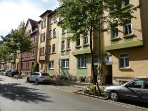 una strada con auto parcheggiate di fronte agli edifici di Jena City Apartment, sonnig, kostenloses Parken & Wifi a Jena