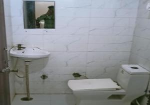 a bathroom with a toilet and a sink and a mirror at Hotel 7 Spices Restaurant & Banquet By WB Inn in Agra