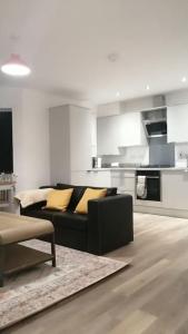 un soggiorno con divano nero e una cucina di Lovely 1-Bedroom Flat in Hinckley, LE10 a Hinckley