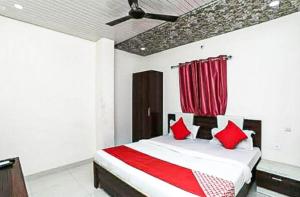 a bedroom with a bed with red pillows at Hotel 7 Spices Restaurant & Banquet By WB Inn in Agra