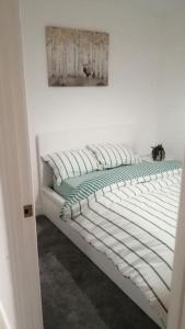 un letto bianco in una stanza con una foto sul muro di Lovely 1-Bedroom Flat in Hinckley, LE10 a Hinckley