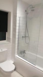 een witte badkamer met een douche en een toilet bij Lovely 1-Bedroom Flat in Hinckley, LE10 in Hinckley