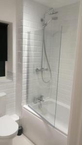 a white bathroom with a shower and a toilet at Lovely 1-Bedroom Flat in Hinckley, LE10 in Hinckley